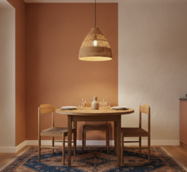Okrogla lesena jedilna miza s tremi stoli in visečo svetilko v toplem jedilnem kotičku.